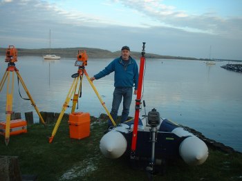 Picture of Peter Russell with a boat and surveying equipment